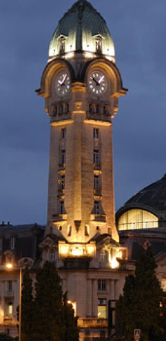 Tour horloge de la gare de Limoges illuminée à la tombée de la nuit.