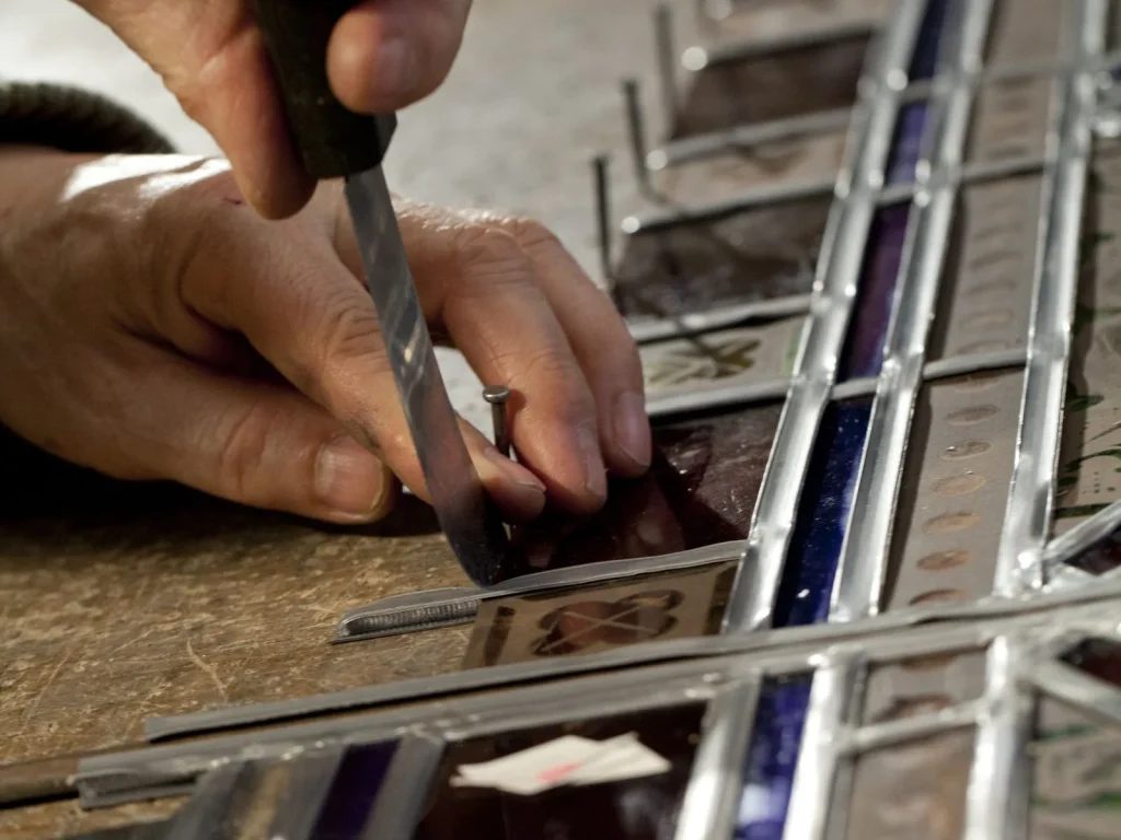 Farbige Glasstücke werden zu einem Glasfenster zusammengesetzt