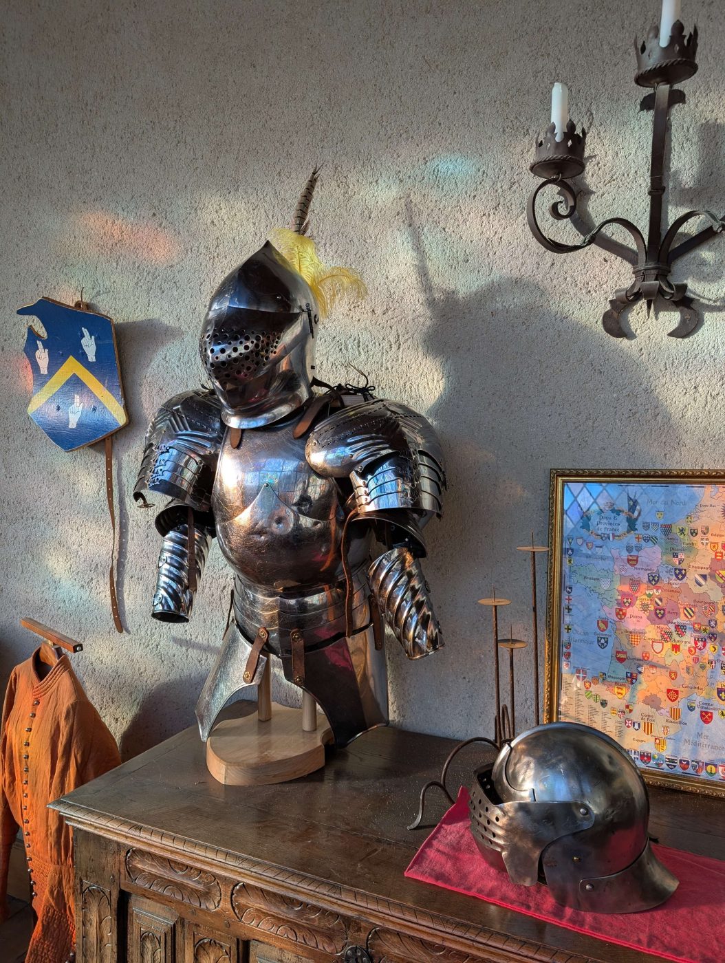 Rüstung und Helm im Schloss, unter dem Wappen der Familie Benoist
